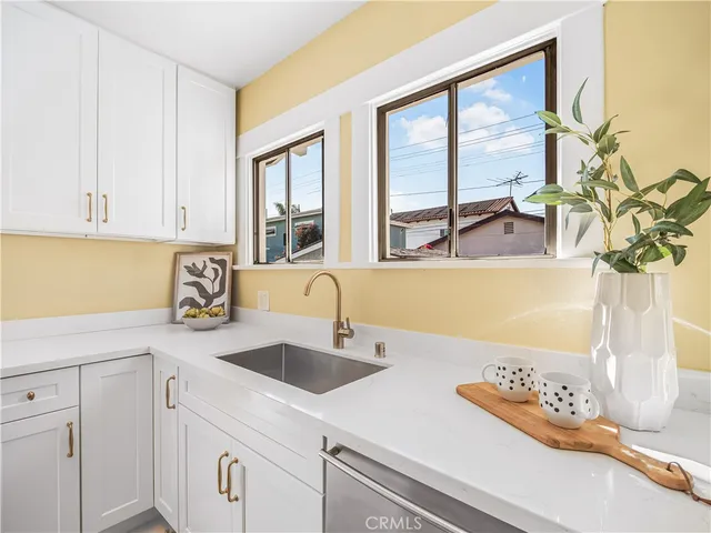 a kitchen with stainless steel appliances granite countertop a sink and a granite counter tops with a large window