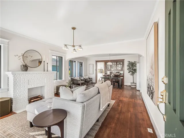 a living room with furniture a fireplace and a chandelier