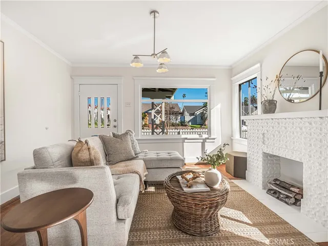 a living room with furniture a fireplace and a chandelier