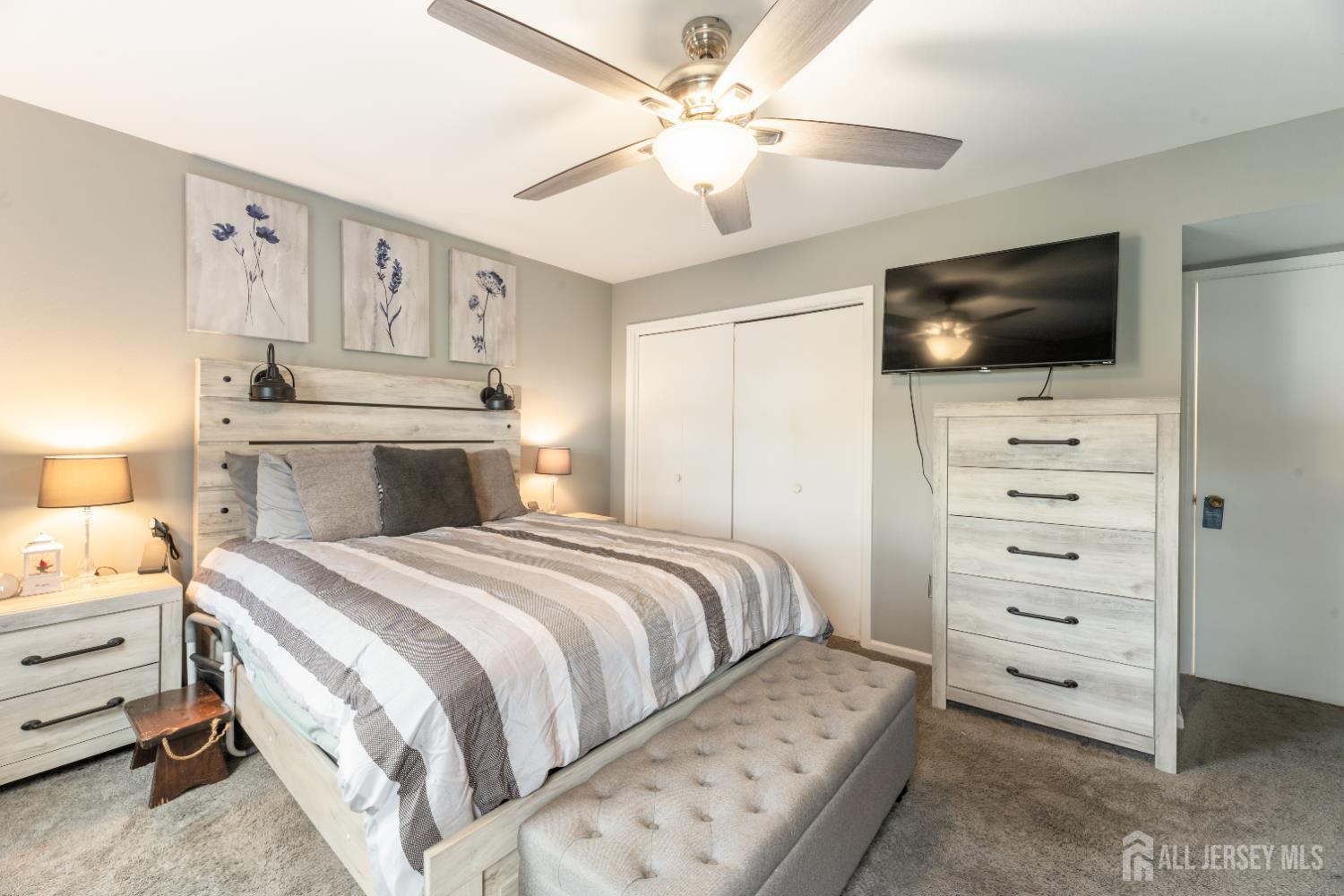 94 Gloucester Way, Unit B Monroe Township, NJ 08831 - Photo 13 of 20 a bedroom with a large bed and a flat tv screen on dresser