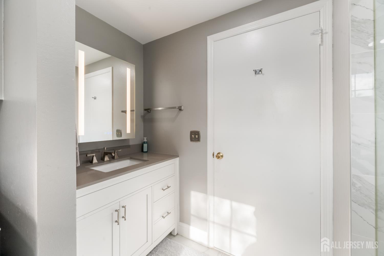 94 Gloucester Way, Unit B Monroe Township, NJ 08831 - Photo 17 of 20 a bathroom with a granite countertop sink a mirror and a shower