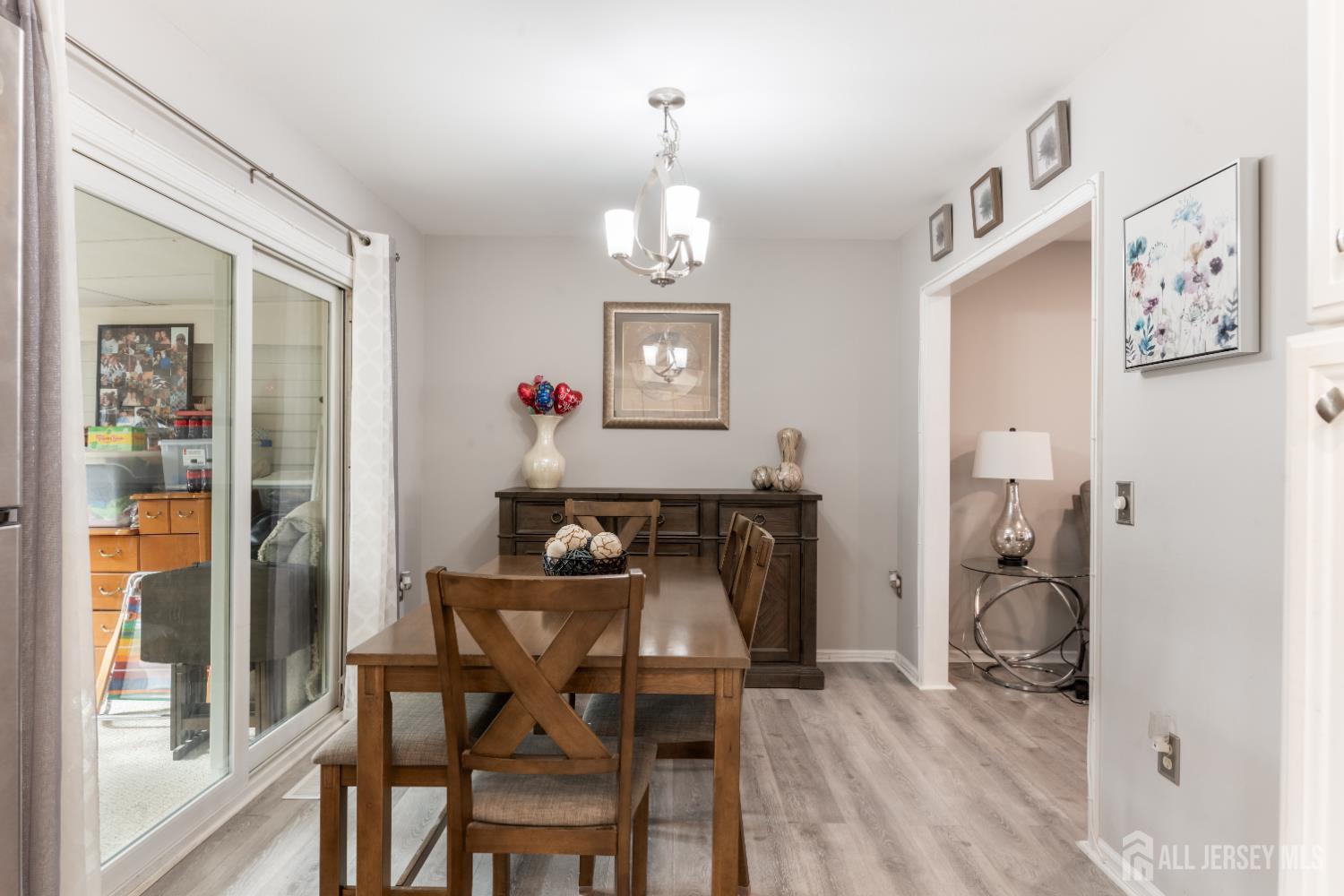94 Gloucester Way, Unit B Monroe Township, NJ 08831 - Photo 7 of 20 a view of a dining room with furniture wooden floor and a chandelier
