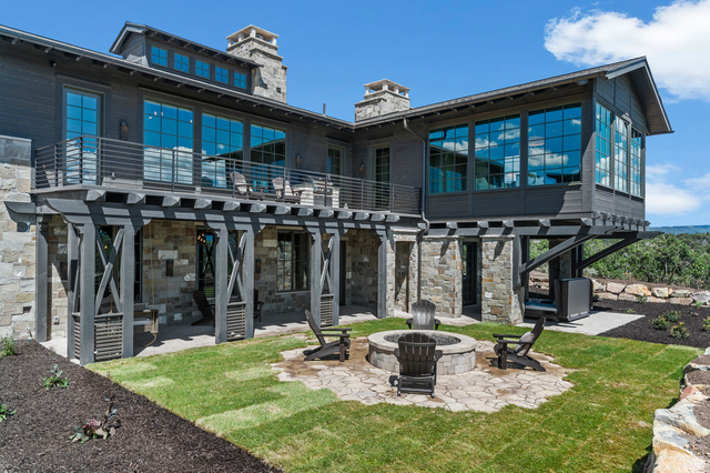 2192 East Outlaw Road Kamas, UT 84036 - Photo 29 of 80 Multi-level exterior featuring stone and wood siding, a second-story balcony with metal railings, and an expansive lower patio with a built-in fire pit