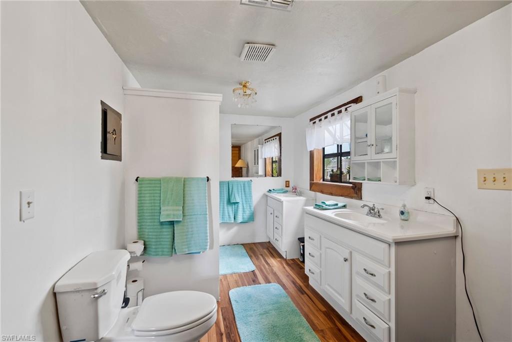 19883 Bristol Road Fort Myers, FL 33908 - Photo 16 of 25 Bathroom featuring wood-type flooring, oversized vanity, and toilet