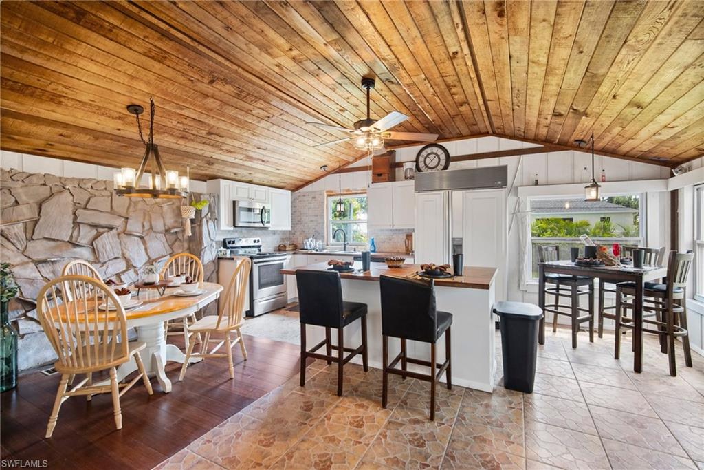 19883 Bristol Road Fort Myers, FL 33908 - Photo 8 of 25 Kitchen with a healthy amount of sunlight, range, lofted ceiling, and tasteful backsplash