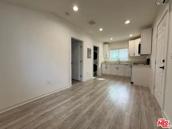 a kitchen with stainless steel appliances granite countertop a refrigerator a sink dishwasher and a stove with wooden floor