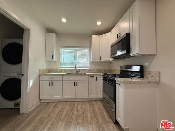 a kitchen with stainless steel appliances granite countertop a stove a sink and a microwave