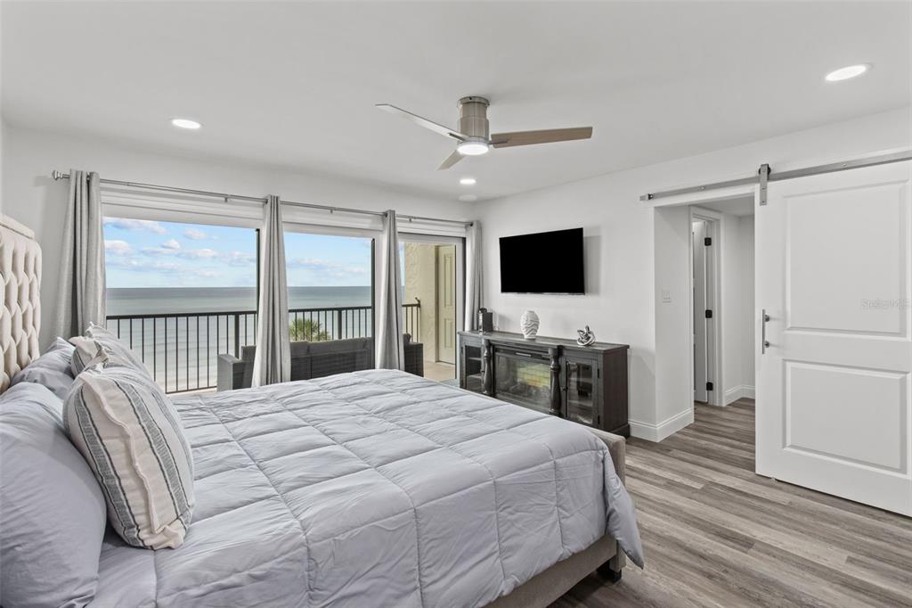 14950 Gulf Boulevard, Unit 503 Madeira Beach, FL 33708 - Photo 17 of 43 a bedroom with a large bed and a flat screen tv