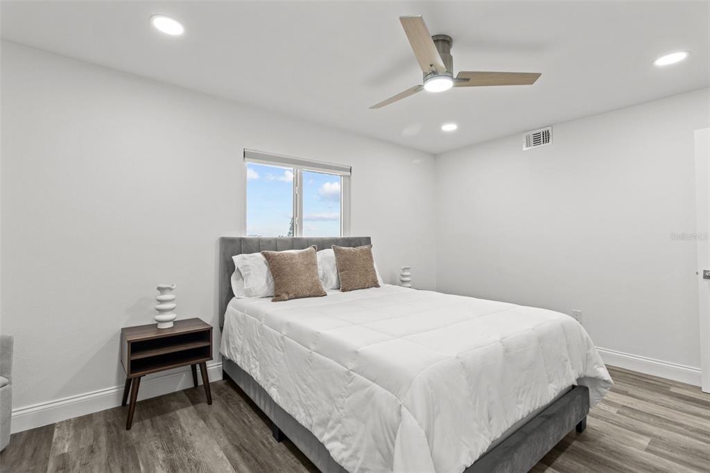 14950 Gulf Boulevard, Unit 503 Madeira Beach, FL 33708 - Photo 25 of 43 a bedroom with a bed and a chandelier