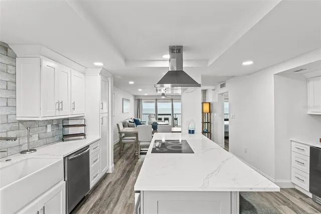 a kitchen that has a sink a stove and a wooden floor