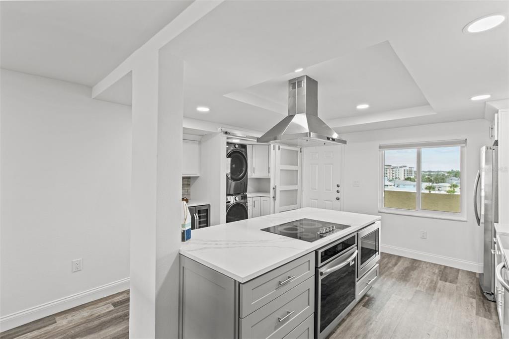 14950 Gulf Boulevard, Unit 503 Madeira Beach, FL 33708 - Photo 6 of 43 a kitchen that has a sink a stove and a wooden floor