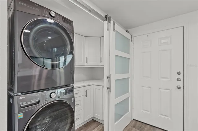 a kitchen with a stove a refrigerator and a sink with wooden floor