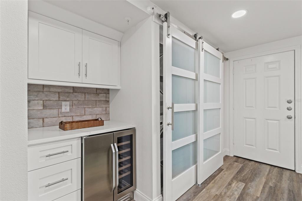 14950 Gulf Boulevard, Unit 503 Madeira Beach, FL 33708 - Photo 10 of 43 a kitchen with white cabinets and a refrigerator