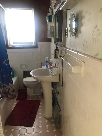 a bathroom with a sink mirror and toilet