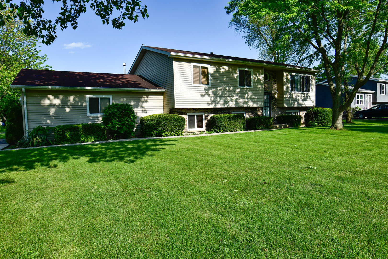 a front view of a house with a yard and green space