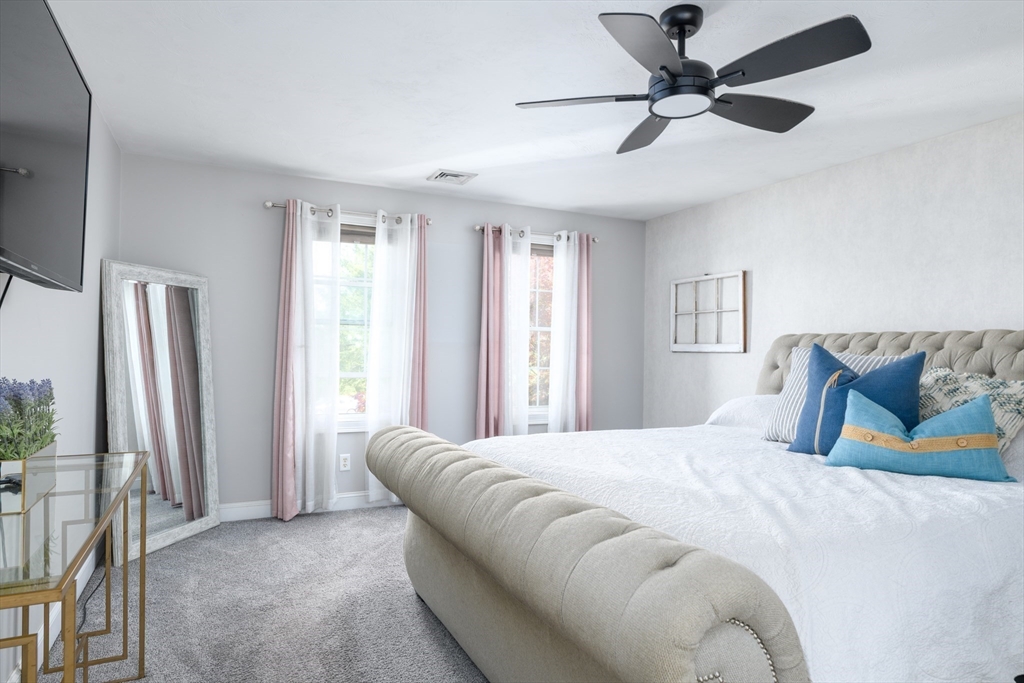 27 Vista Circle Rutland, MA 01543 - Photo 14 of 35 a bedroom with a large bed and a chandelier
