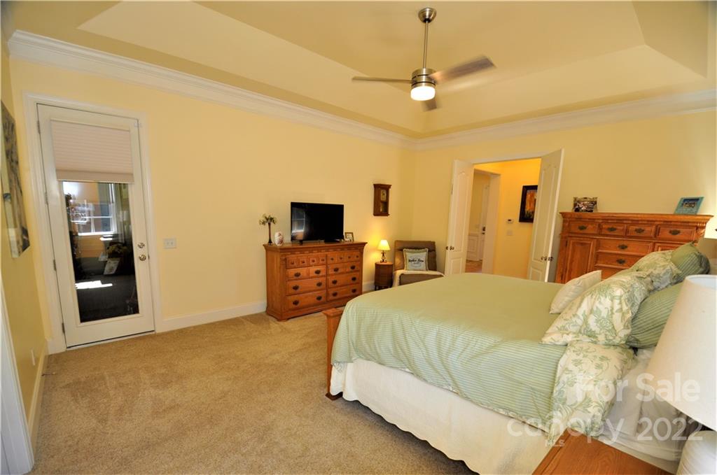 186 Chaska Loop Troutman, NC 28166 - Photo 15 of 48 a spacious bedroom with a bed and a flat screen tv