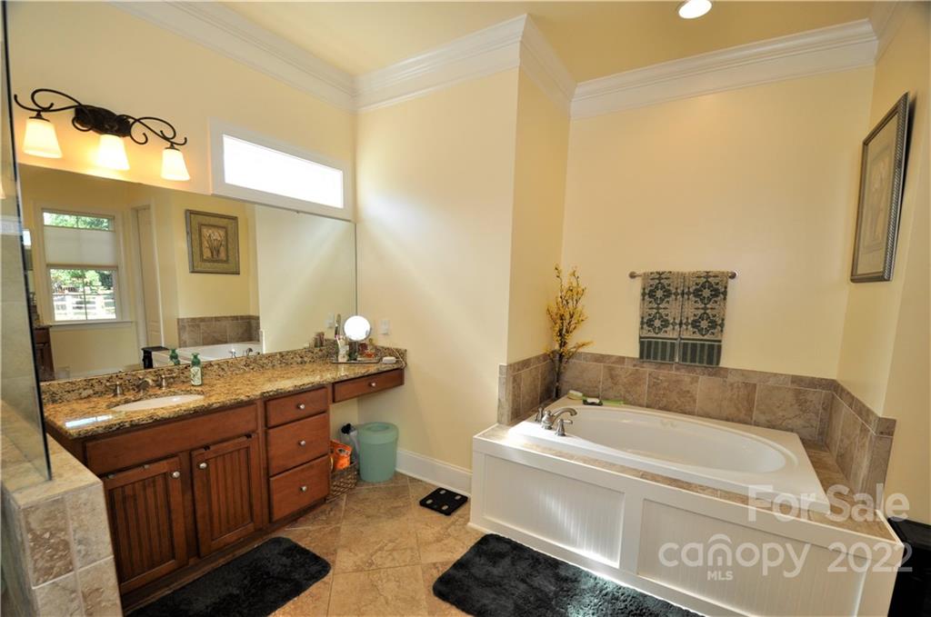 186 Chaska Loop Troutman, NC 28166 - Photo 18 of 48 a spacious bathroom with a tub sink and mirror