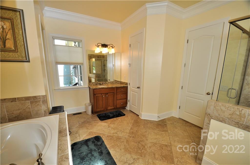 186 Chaska Loop Troutman, NC 28166 - Photo 19 of 48 a spacious bathroom with a tub sink and mirror