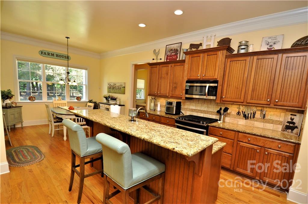 186 Chaska Loop Troutman, NC 28166 - Photo 26 of 48 a kitchen with granite countertop a stove a sink and a refrigerator