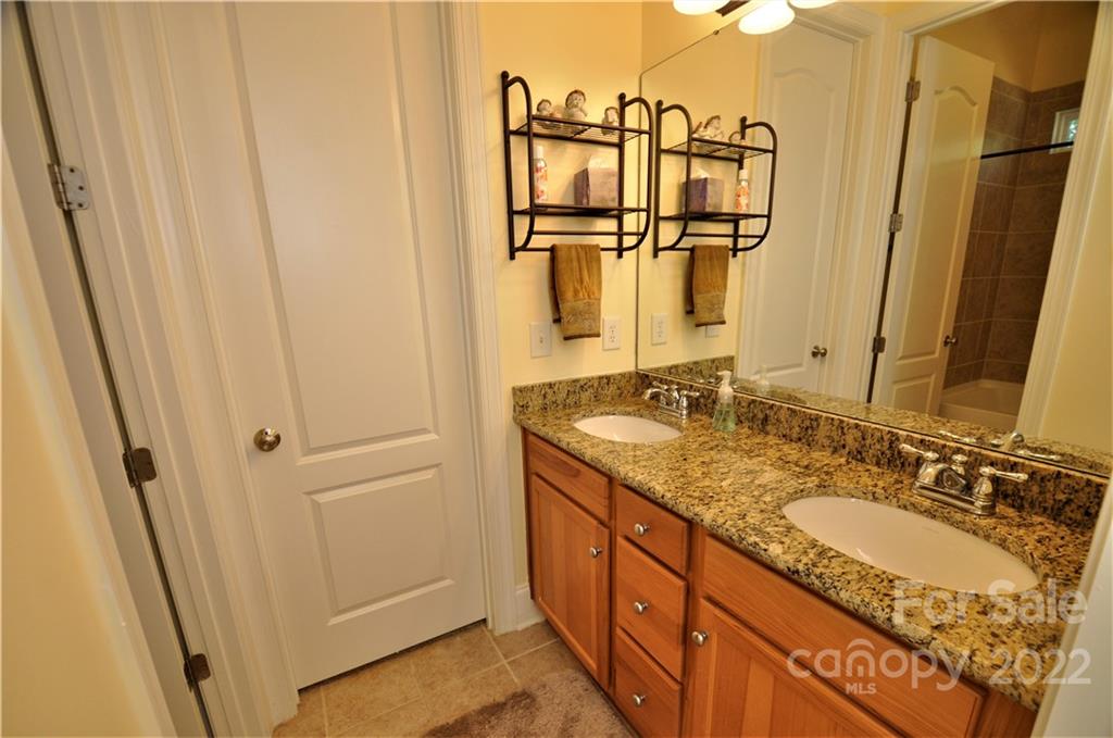 186 Chaska Loop Troutman, NC 28166 - Photo 34 of 48 a bathroom with a granite countertop sink and a mirror