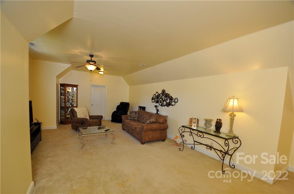 186 Chaska Loop Troutman, NC 28166 - Photo 40 of 48 a living room with furniture and a chandelier
