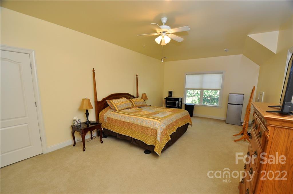 186 Chaska Loop Troutman, NC 28166 - Photo 43 of 48 a bedroom with a bed and a chandelier