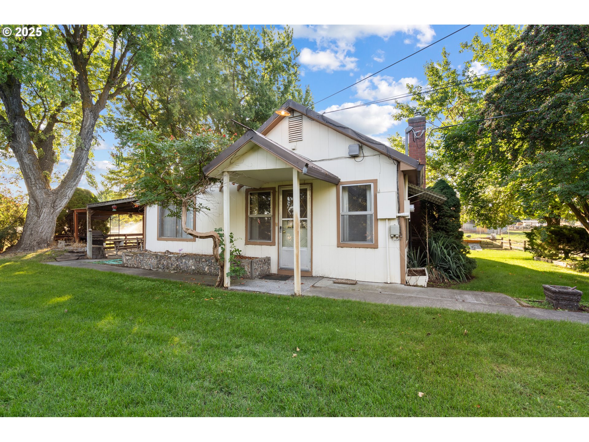 32534 Diagonal Boulevard Hermiston, OR 97838 - Photo 1 of 35 a big white house with a big yard and large trees