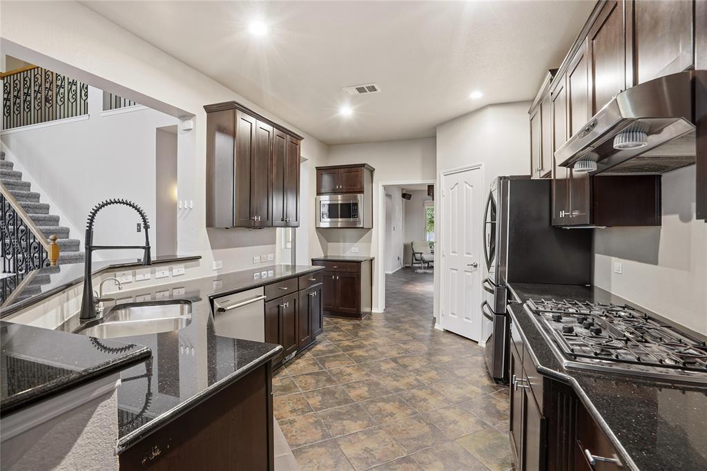 1017 Long Pointe Avenue Fort Worth, TX 76108 - Photo 6 of 28 a kitchen with stainless steel appliances granite countertop a stove refrigerator sink and cabinets