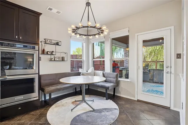 a living room with furniture a chandelier and a fireplace