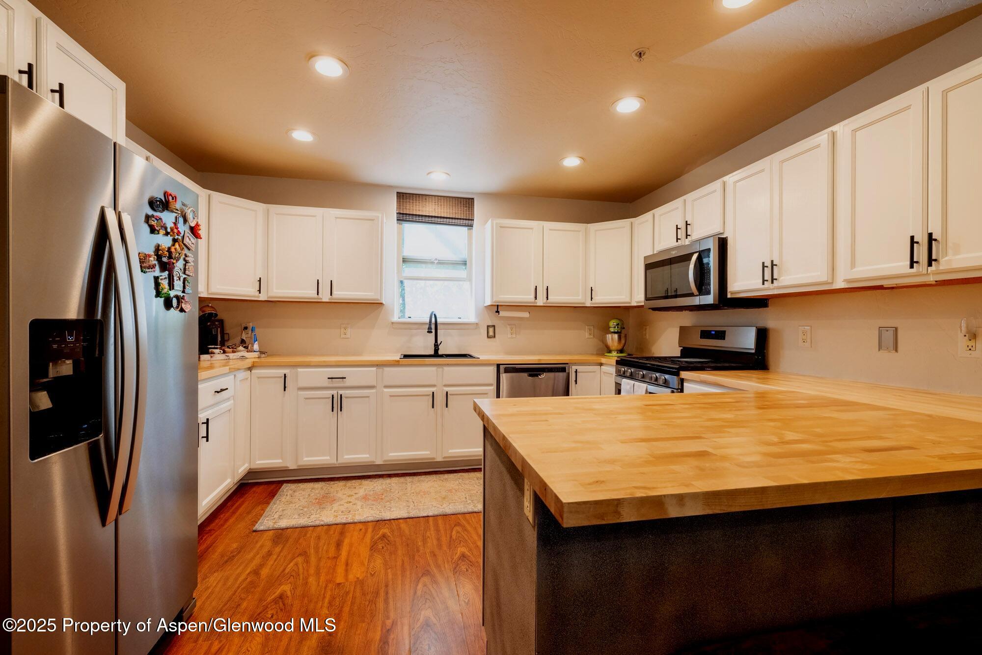 a kitchen with stainless steel appliances a stove refrigerator sink and cabinets