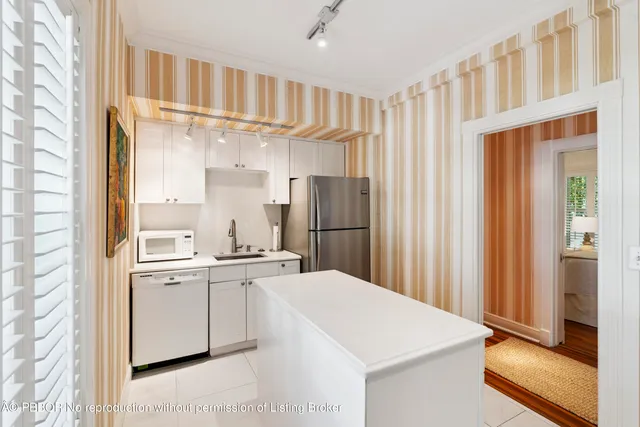 a kitchen with a sink a refrigerator and cabinets