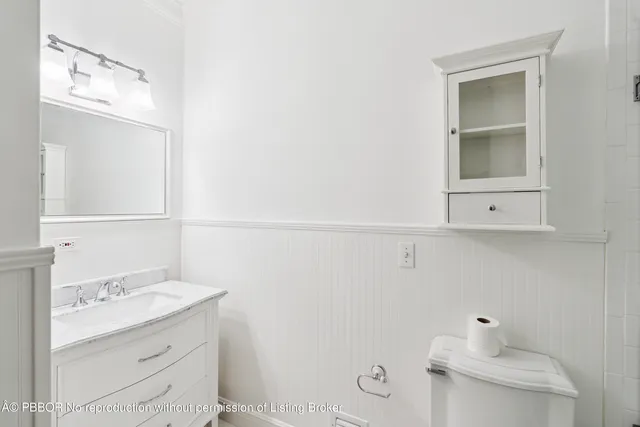 a bathroom with a sink a toilet and mirror