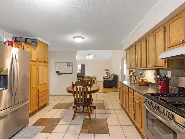 a kitchen with granite countertop a refrigerator and a stove top oven