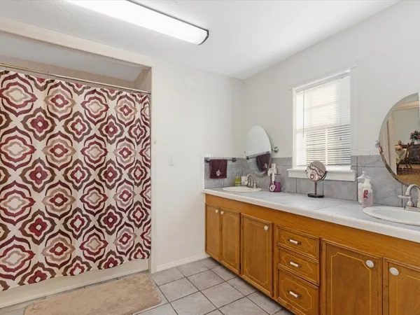 a spacious bathroom with a mirror and double sink