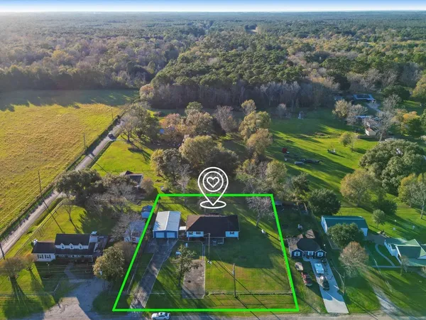 an aerial view of a house with a yard and lake view