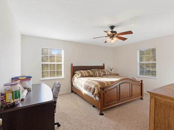 a spacious bedroom with a bed and a table in it