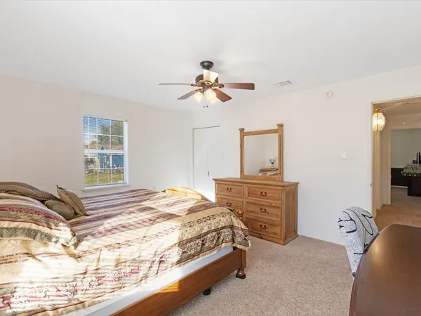 a bedroom with a bed dresser and a window