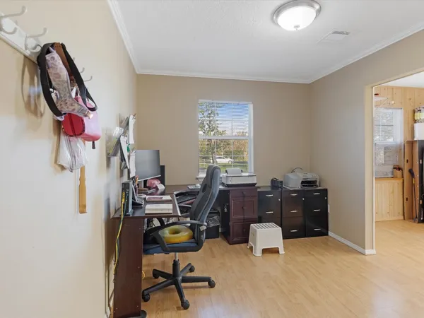 a view of a workspace with furniture and a window