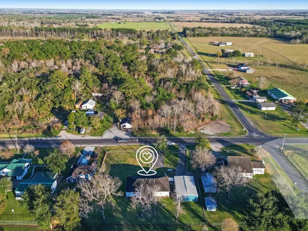 an aerial view of residential house with outdoor space and trees all around