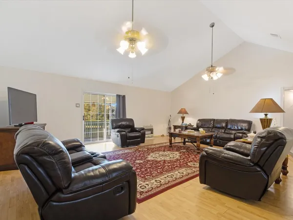 a living room with furniture a chandelier and a flat screen tv