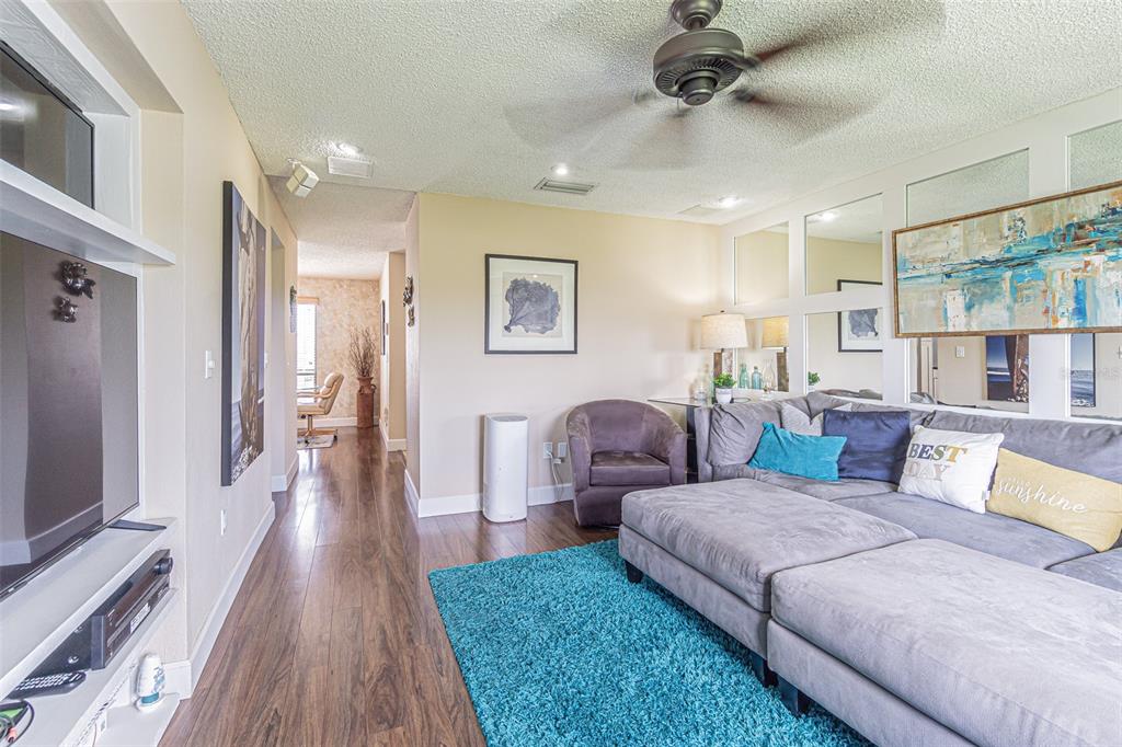 1 Windrush Boulevard, Unit 54 Indian Rocks Beach, FL 33785 - Photo 13 of 37 a bed room with large bed and a chandelier