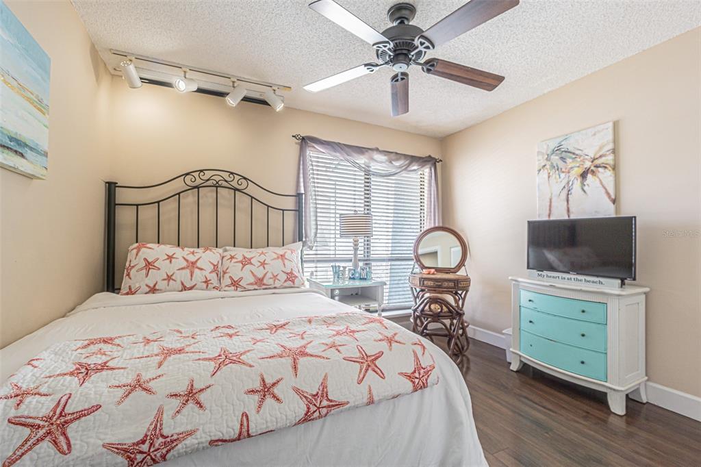 1 Windrush Boulevard, Unit 54 Indian Rocks Beach, FL 33785 - Photo 18 of 37 a bedroom with a large bed and a tv