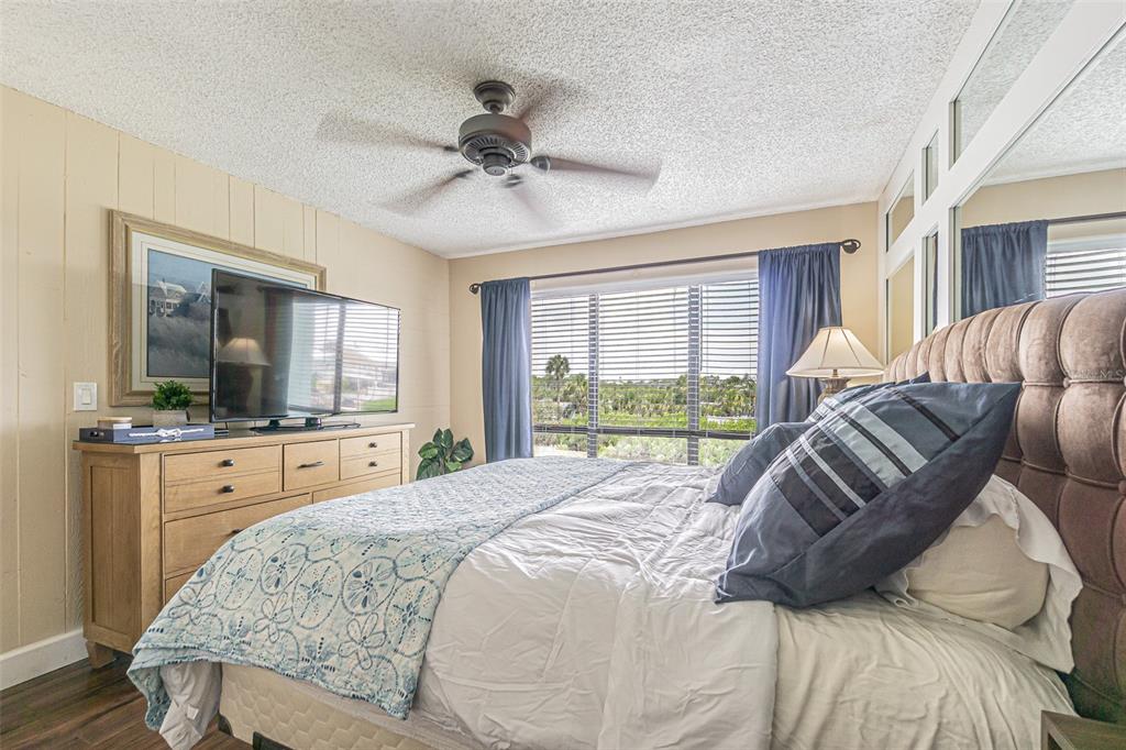 1 Windrush Boulevard, Unit 54 Indian Rocks Beach, FL 33785 - Photo 20 of 37 a bedroom with a large bed and a flat screen tv