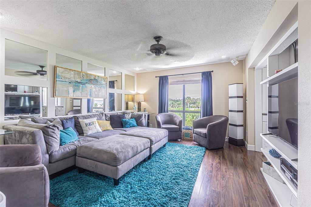 1 Windrush Boulevard, Unit 54 Indian Rocks Beach, FL 33785 - Photo 7 of 37 a living room with furniture and a large window
