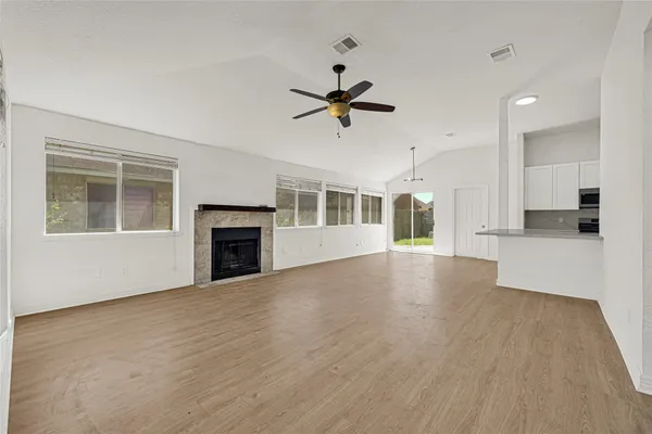a view of empty room with wooden floor and fireplace