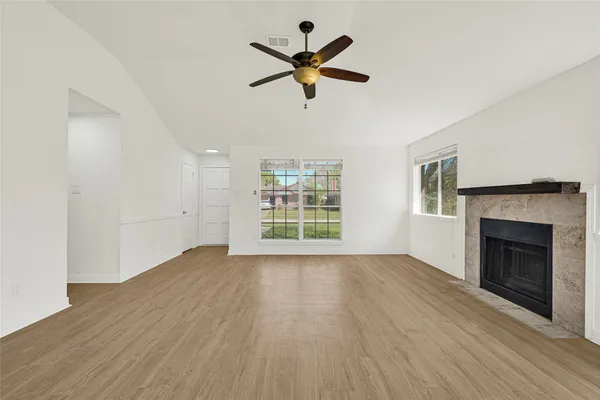 a view of empty room with wooden floor and fireplace