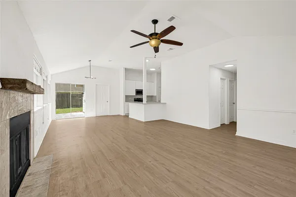 a view of empty room with wooden floor and ceiling fan
