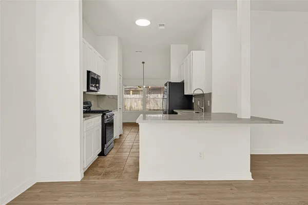 a kitchen with stainless steel appliances a refrigerator and a stove top oven