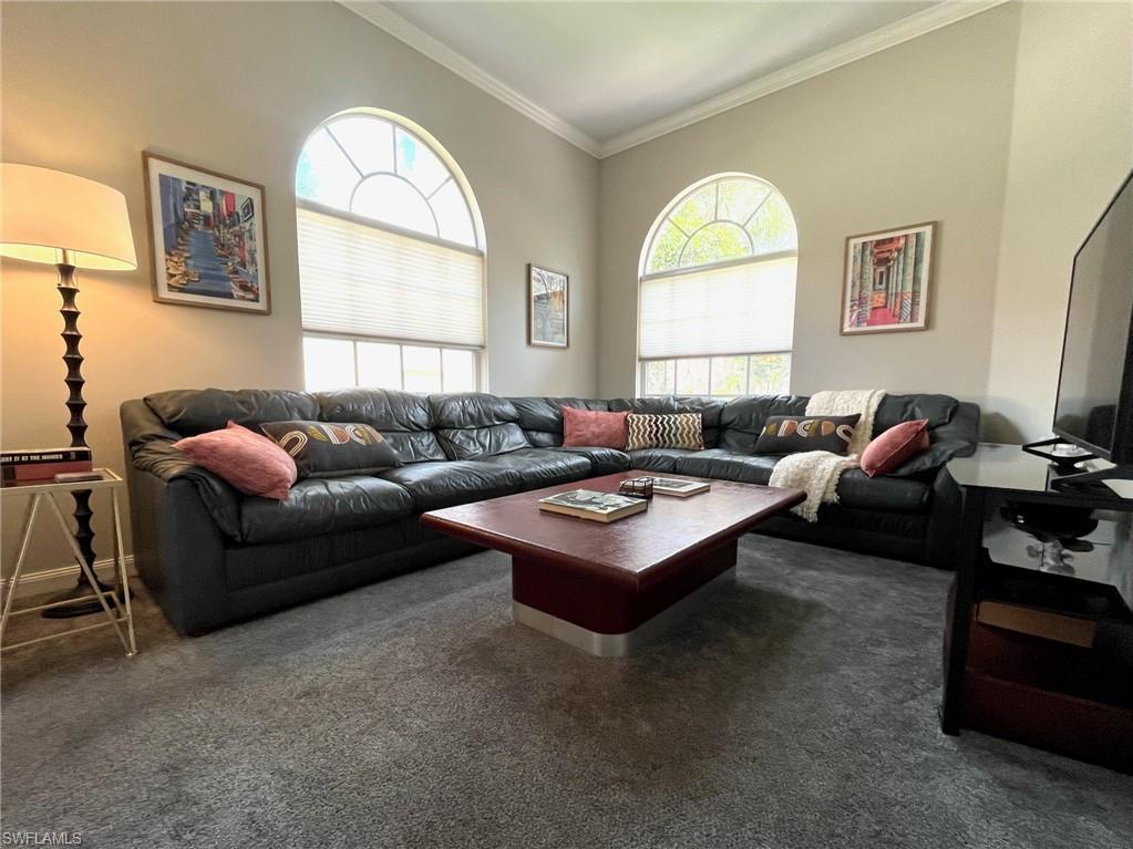 5477 Freeport Lane Naples, FL 34119 - Photo 21 of 36 a living room with furniture a large window and a flat screen tv